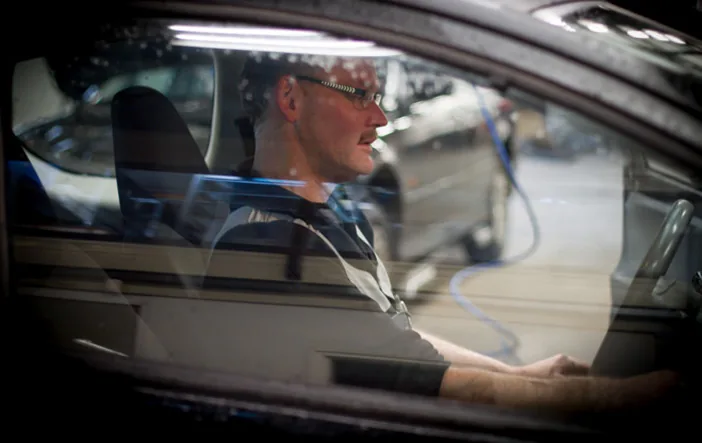 APK-keurmeester achter het stuur tijdens een keuring bij Autobedrijf Kees