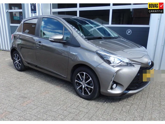 Grijze Toyota Yaris Hybrid voor het pand van Autobedrijf Kees